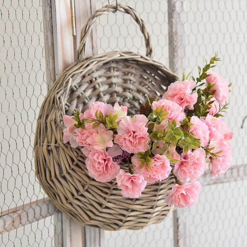 Two hanging rattan wall baskets filled with ivy
