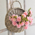 Two hanging rattan wall baskets filled with ivy
