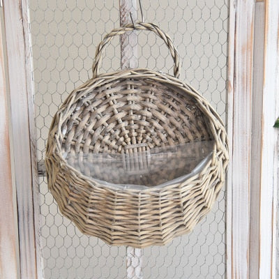 Two hanging rattan wall baskets filled with ivy