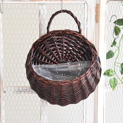 Two hanging rattan wall baskets filled with ivy