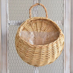 Two hanging rattan wall baskets filled with ivy