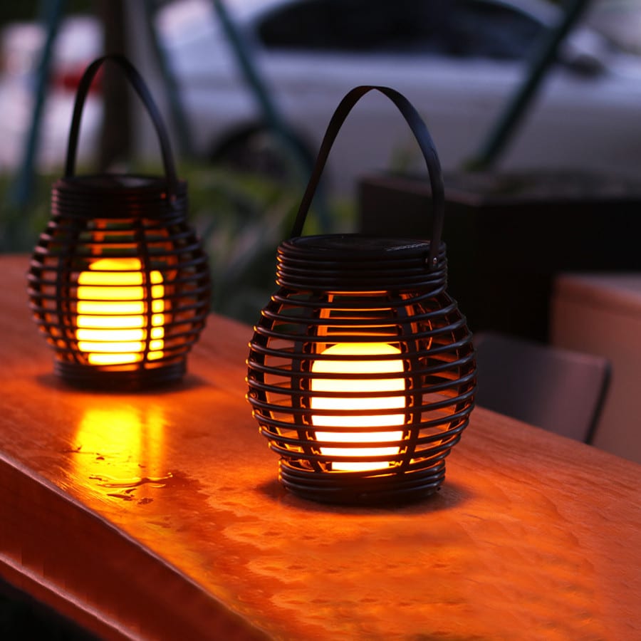 Small hanging hand woven rattan solar lantern with a handle