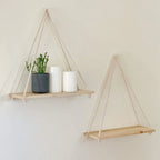 Natural wood shelf hung from a braided rope