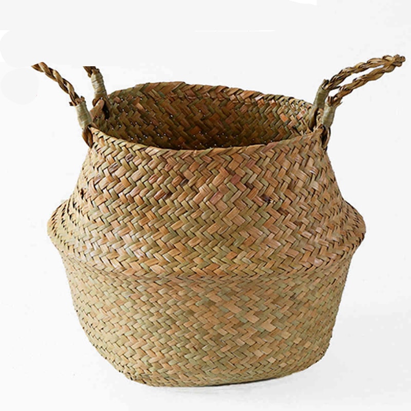 Three small woven belly baskets hanging on wall hooks with plants