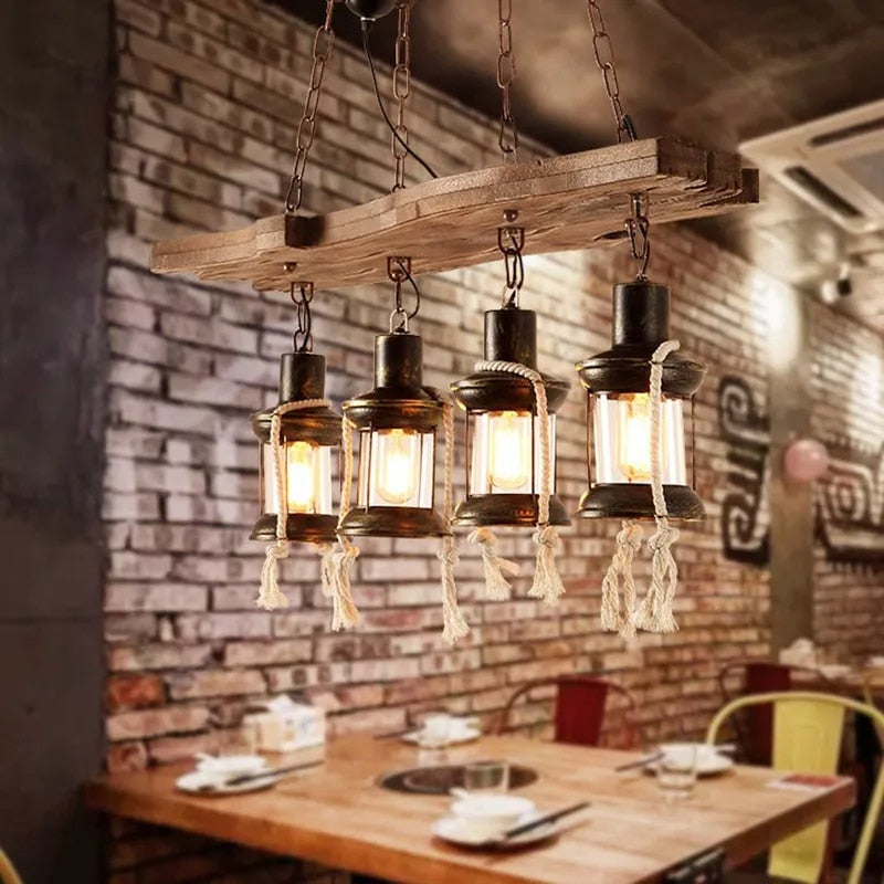 Industrial pendant light with a natural wood branch and four geometric black metal lanterns