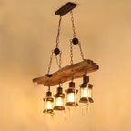 Industrial pendant light with a natural wood branch and four geometric black metal lanterns