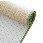 Rolled Japanese rattan mat with a green border and dotted non-slip backing