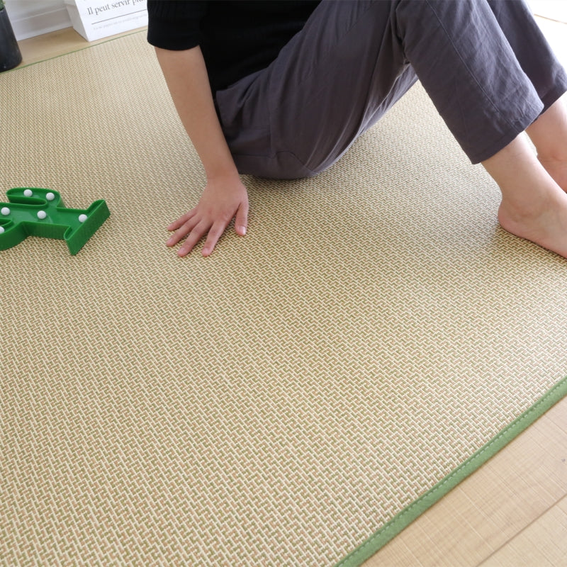 Rolled Japanese rattan mat with a green border and dotted non-slip backing