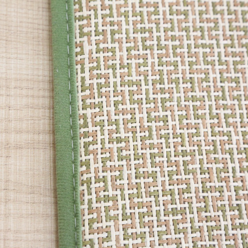 Rolled Japanese rattan mat with a green border and dotted non-slip backing