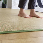Rolled Japanese rattan mat with a green border and dotted non-slip backing
