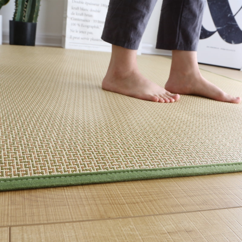 Rolled Japanese rattan mat with a green border and dotted non-slip backing
