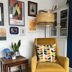 Japanese style floor lamp with a curved hand woven rattan shade and a dark metal stand