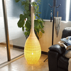 Japanese lantern style standing lamp with tight hand woven wicker slats on a wood base