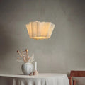 White pleated fabric pendant light above a table