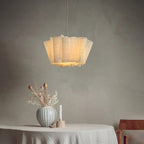 White pleated fabric pendant light above a table