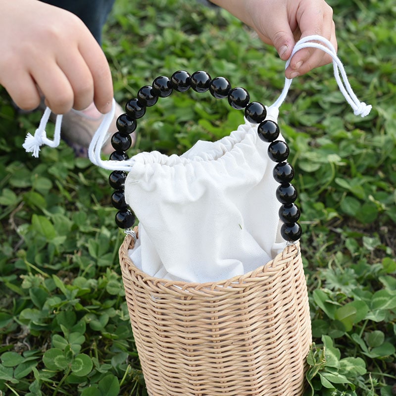 Small woven basket with bead handle and white drawstring liner