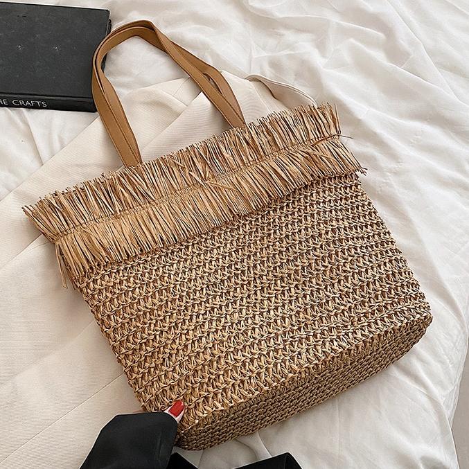 Large brown woven straw shoulder bag with fringe trim