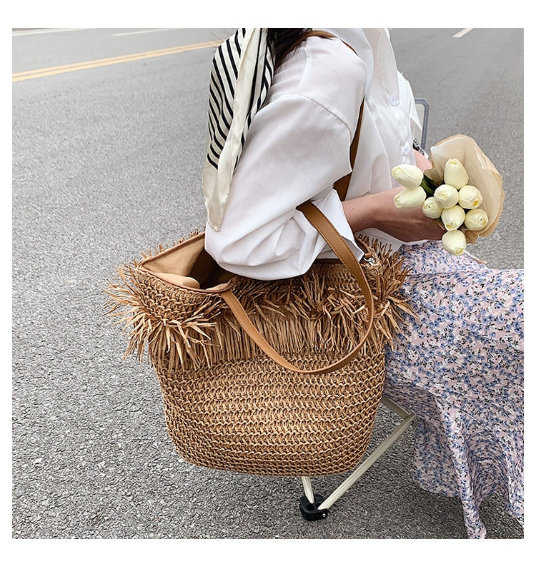 Large brown woven straw shoulder bag with fringe trim