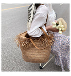 Large brown woven straw shoulder bag with fringe trim