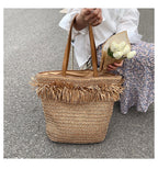 Large brown woven straw shoulder bag with fringe trim