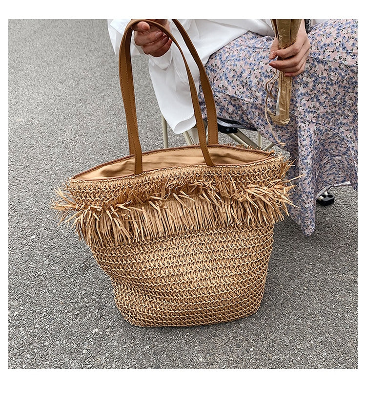 Large brown woven straw shoulder bag with fringe trim