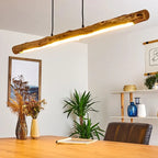 Large horizontal natural wood log pendant light on an iron structure
