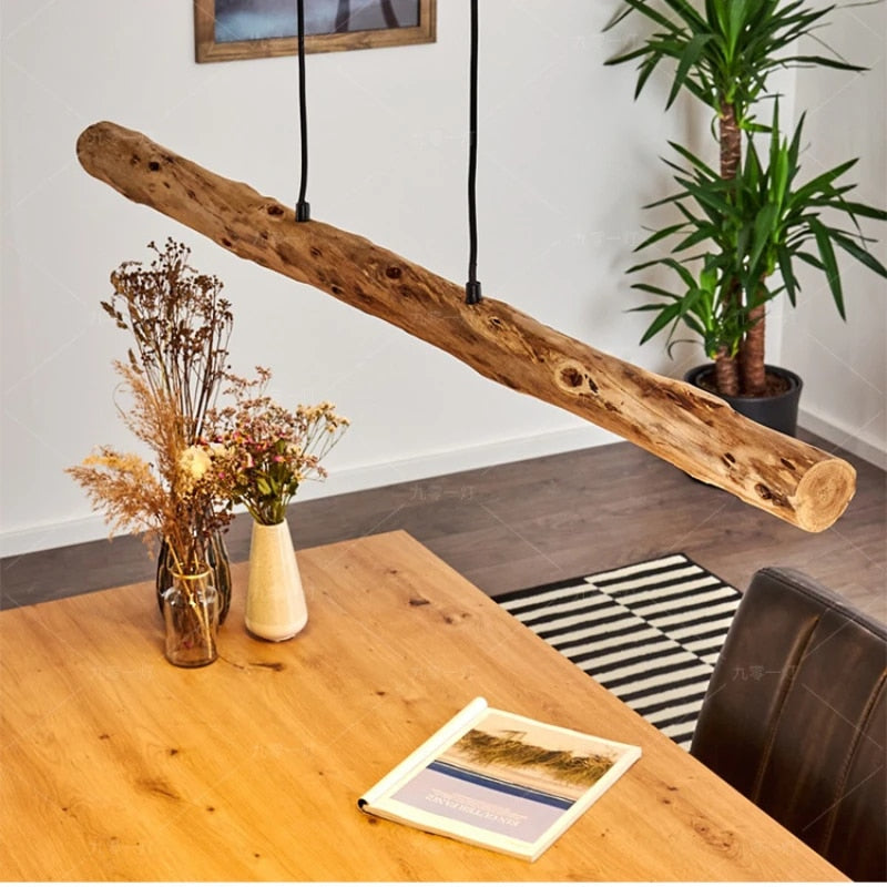 Large horizontal natural wood log pendant light on an iron structure