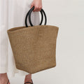 Large oval hand woven rattan handbag with an airy weave and a bamboo toggle