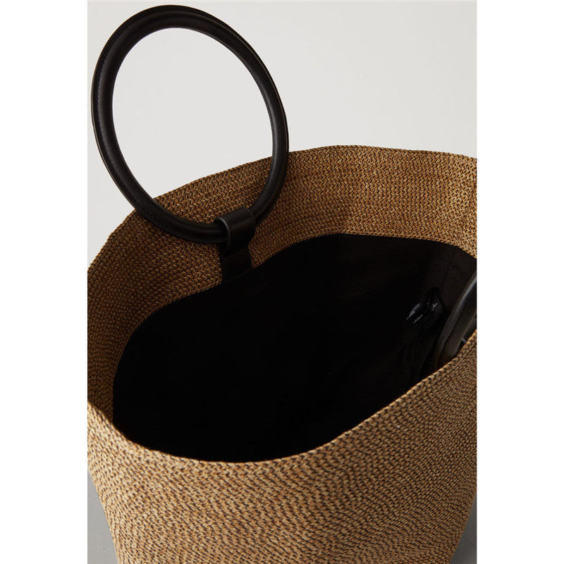 Large oval hand woven rattan handbag with an airy weave and a bamboo toggle