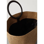 Large oval hand woven rattan handbag with an airy weave and a bamboo toggle