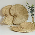 Large round woven fan on a bamboo frame, shown in a group on a console