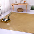 Large square woven rattan mat under a low table