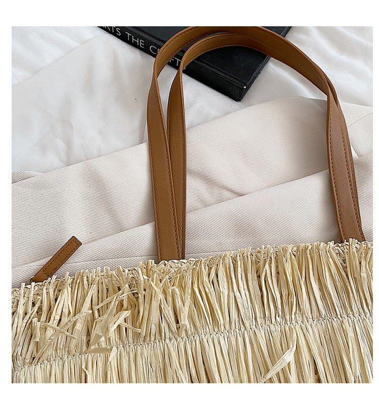 Large white woven straw shoulder bag with fringe trim