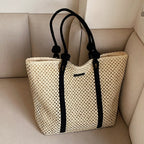 Large structured woven straw tote with sturdy handles and a fabric lining