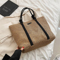 Large structured woven straw tote with sturdy handles and a fabric lining