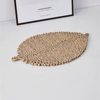 Leaf shaped placemat hand woven in golden straw with raised ribs