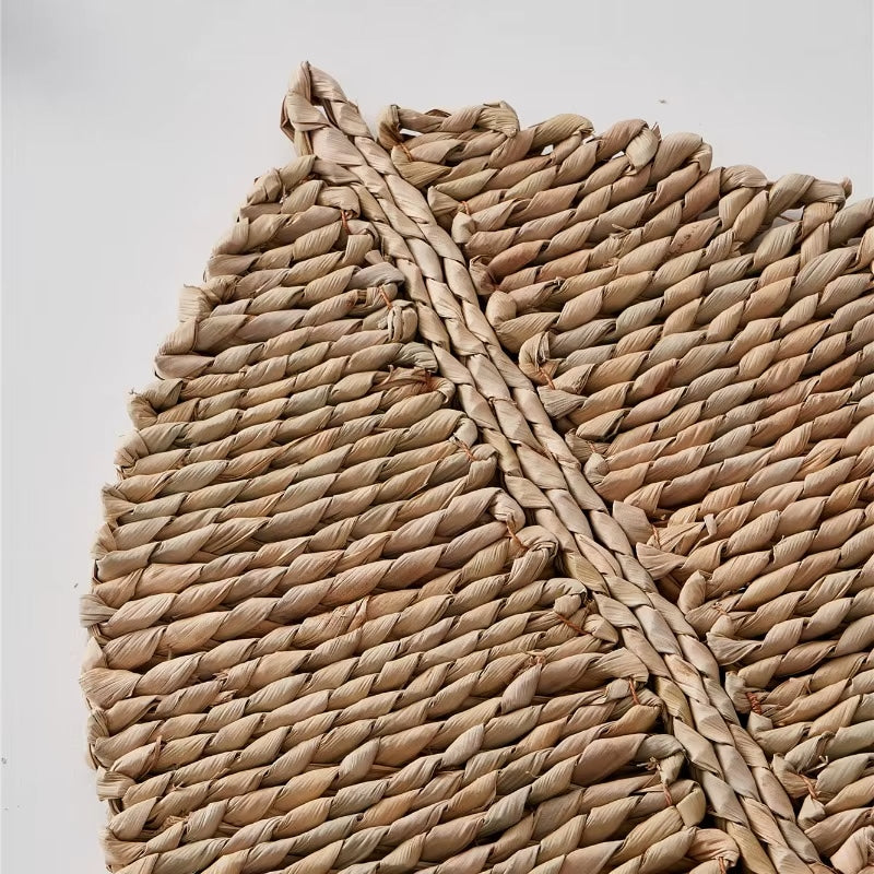 Leaf shaped placemat hand woven in golden straw with raised ribs