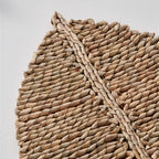 Leaf shaped placemat hand woven in golden straw with raised ribs
