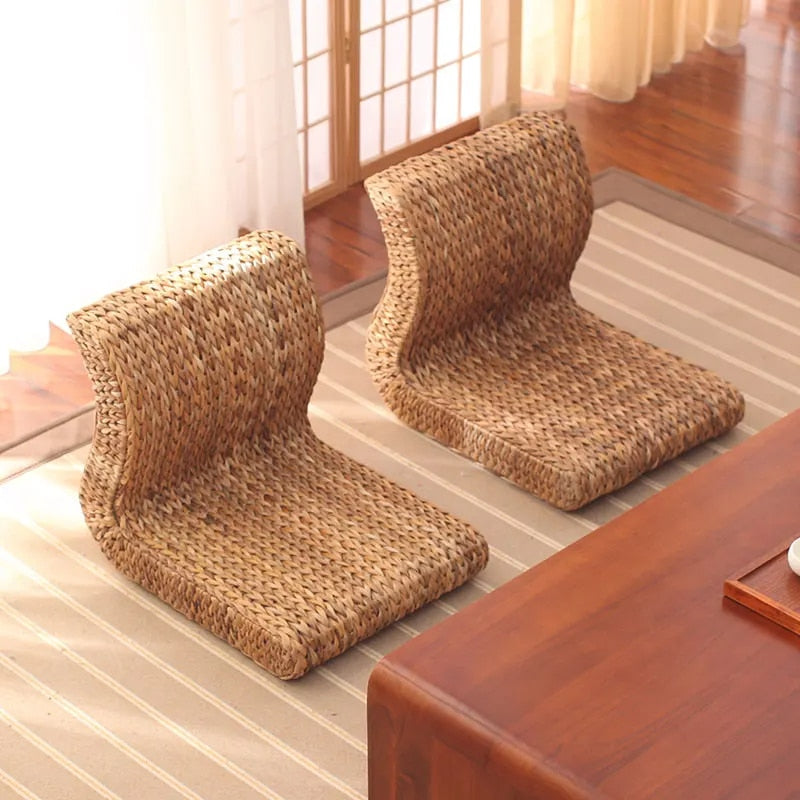 Brown legless floor chair on a curved hand woven rattan base