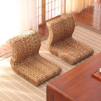 Brown legless floor chair on a curved hand woven rattan base