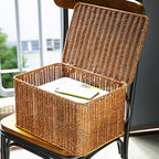 Rectangular woven storage basket with open lid holding papers