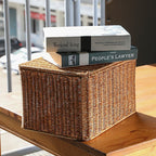 Rectangular woven storage basket with open lid holding papers