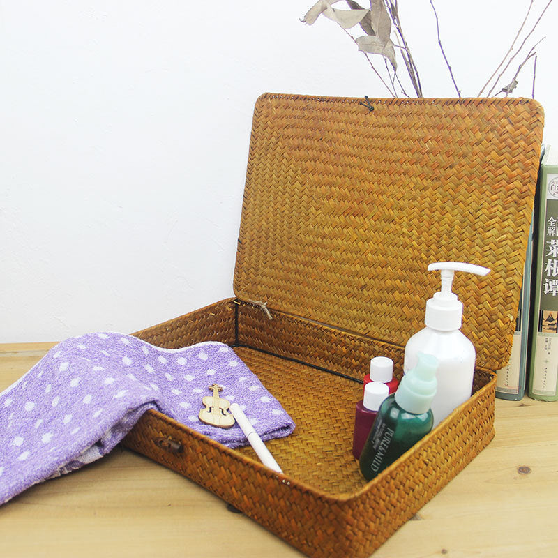 Low flat storage box hand woven in light natural rattan with a lid