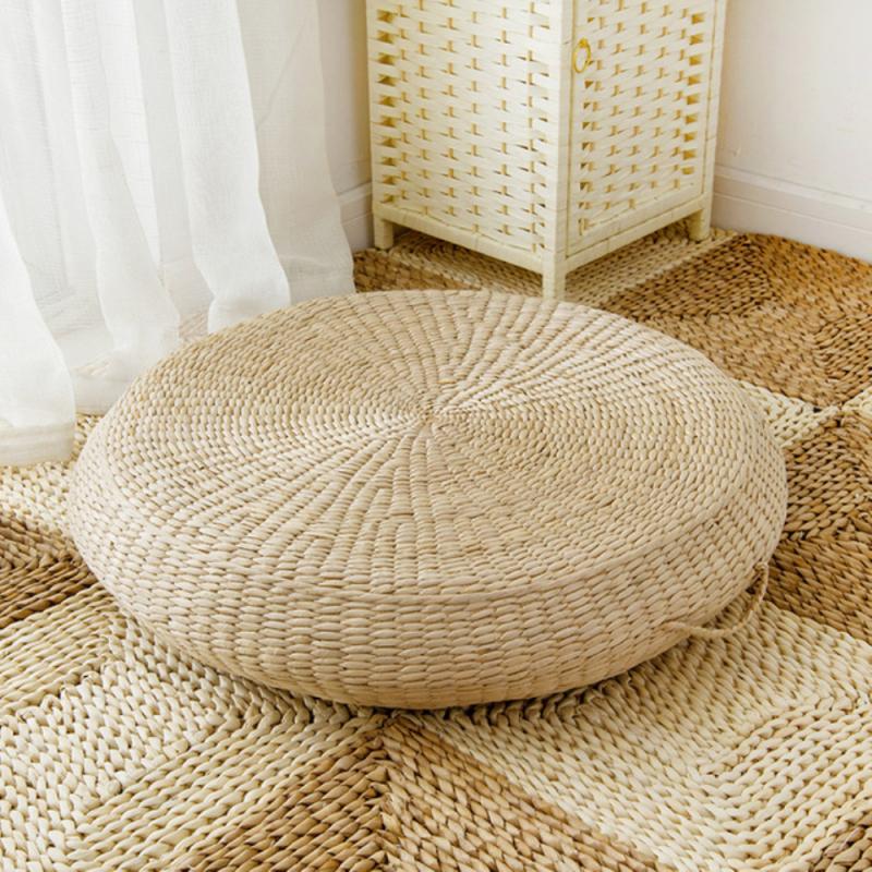 Round light rattan pouf with a built in carry handle