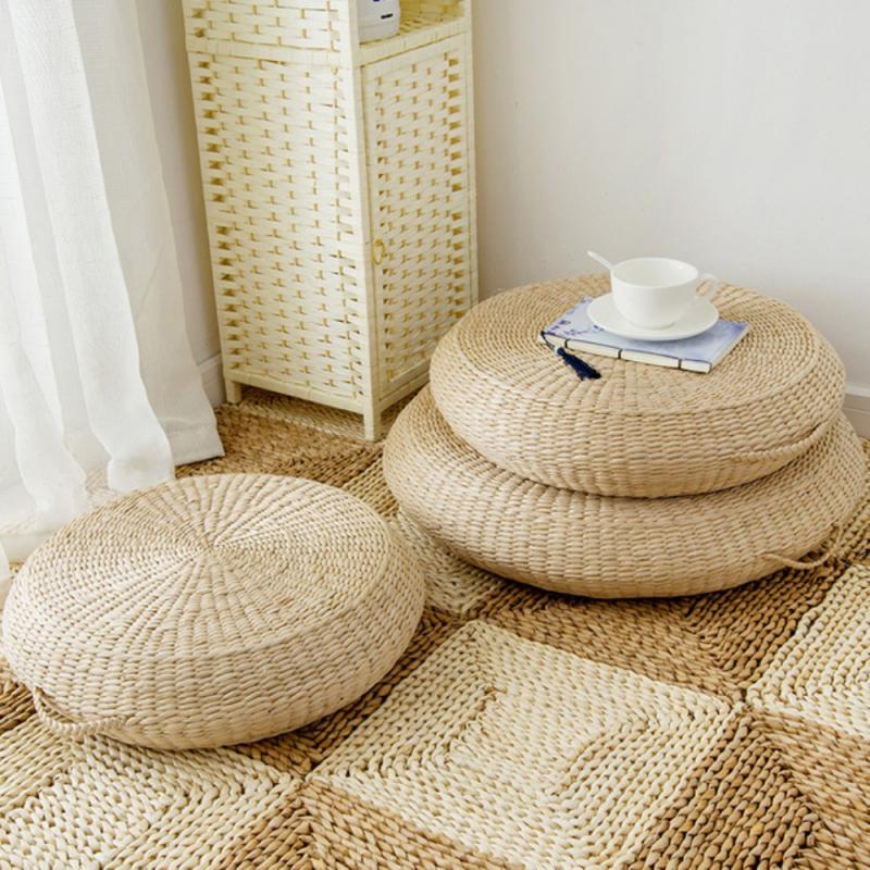 Round light rattan pouf with a built in carry handle