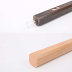 Slim light natural wood wall vase holding a single stem