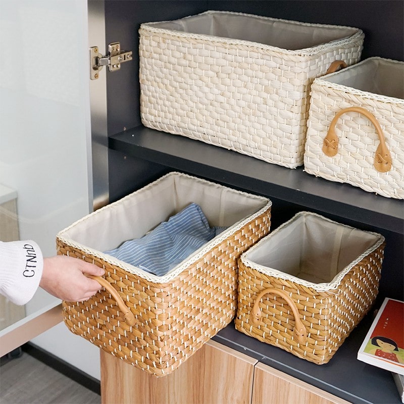 Lined woven storage boxes with handles on shelves