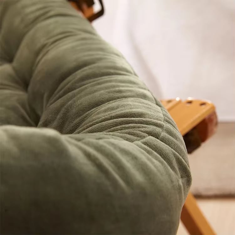 Long deep green polyester cushion covering the seat and back of a chair