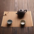 Long honey toned woven bamboo table runner in a Japanese style