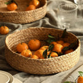 Low round woven basket filled with oranges